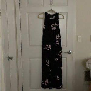 A black jumpsuit with mauve and gray flower.